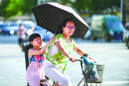 <br>          7月10日，太原市亲贤北街上，一个小姑娘为骑行的母亲打伞遮阳。本报记者 董元炜 摄<br><br>        