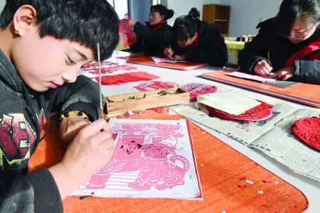 <br>          12月2日，在中国广灵剪纸文化产业园区，剪纸艺人们正在制作《瑞狗迎春》剪纸作品。 本报记者 吕汉富 摄<br><br>        
