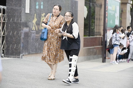 <br>          一位腿部受伤的女生在母亲的搀扶下来到考点。 本报记者 董元炜 摄<br><br>        