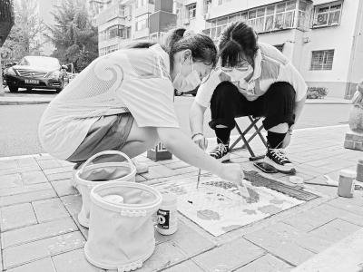 <br>          大学生志愿者在井盖上勾勒图案 图片由晋城市青年志愿者协会提供<br><br>        