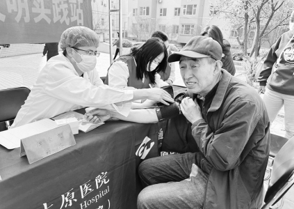           医务志愿者为辖区居民测量血压 图片由太原市坞城街道学府街东社区提供        