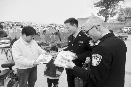           民警向过往群众宣传毒品的危害 图片由永济董村强制隔离戒毒所提供        