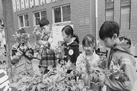           孩子们用花束和绿植扮靓社区 图片由团太原市万柏林区委提供        