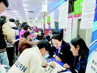           求职者正在企业展位前填写求职信息 本报记者 高静 摄        