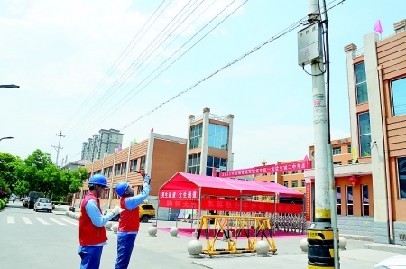          交城二中考点外，交城供电公司员工正巡查电力线路。本报记者 贺建锋 摄        