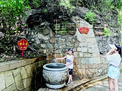           汩汩泉水吸引游客拍照留念 本报记者 康乐 摄        