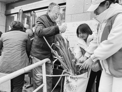           志愿者帮老人领取新鲜的大葱 图片由万柏林区融媒体中心提供        