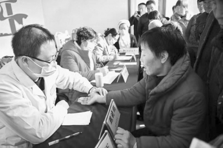           医务人员为村民问诊看病        