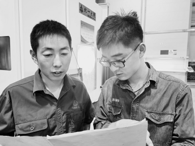           王胜（右）平时不善言辞，喜欢琢磨数控车生产中的难题。 图片由受访者提供        