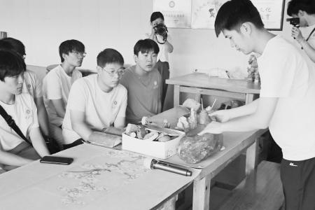 实践团成员在琉璃工坊认真学习琉璃上釉方式 王鸣江 摄
