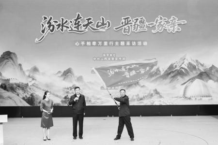 山西省委宣传部副部长王招宇（中）为采访团授旗